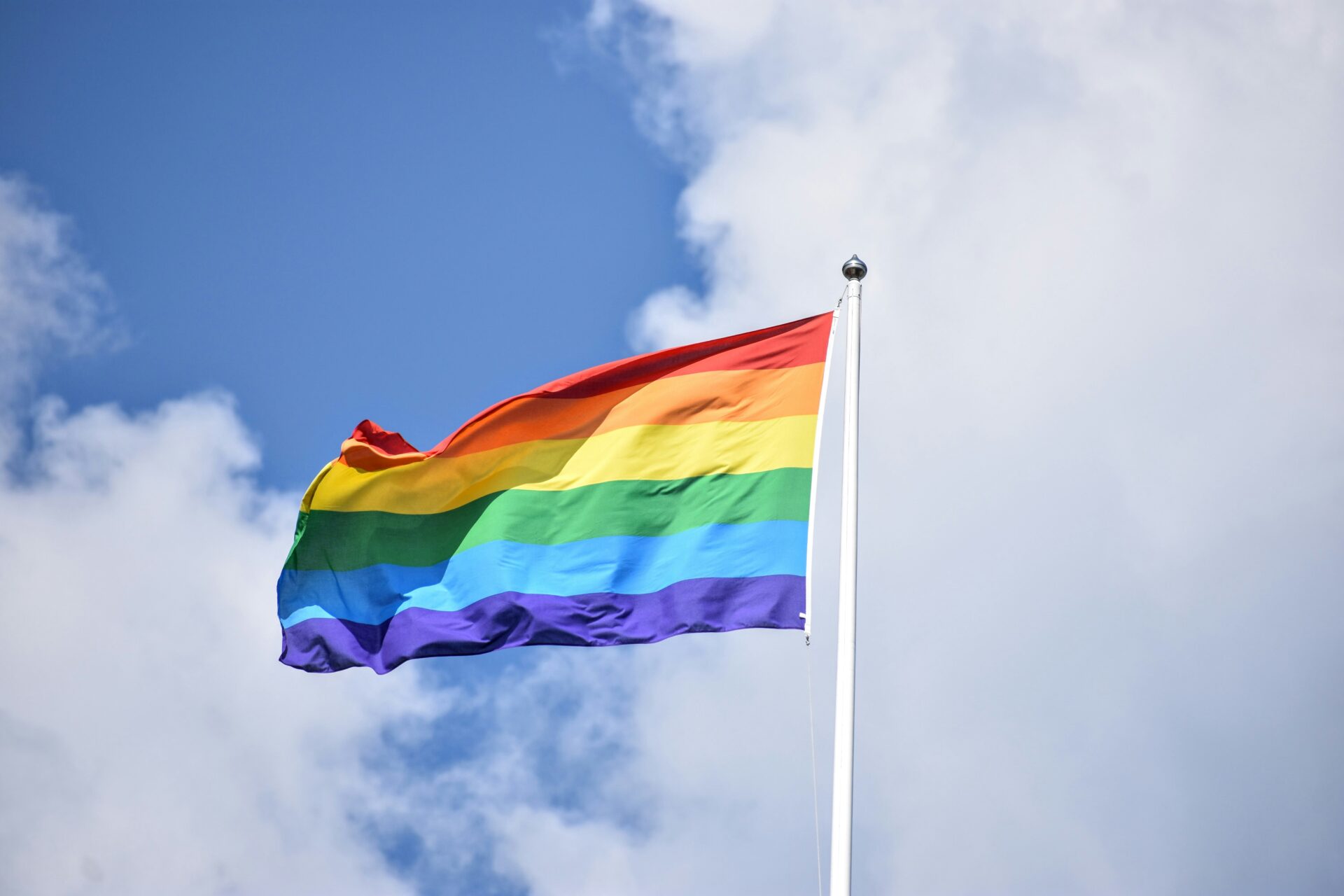 Rainbow flag A rainbow flag flying in front of the blue sky